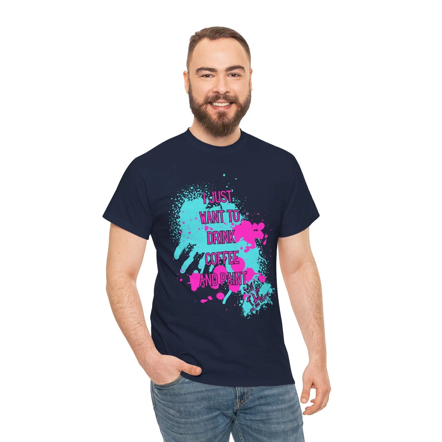 A man with a beard is wearing the "I Just want to Drink Coffee" T-shirt, a classic fit navy shirt made from 100% cotton. It features vibrant splatter designs and text that declares, "I just want to drink coffee and print." He stands against a white background, smiling with one hand in his pocket.