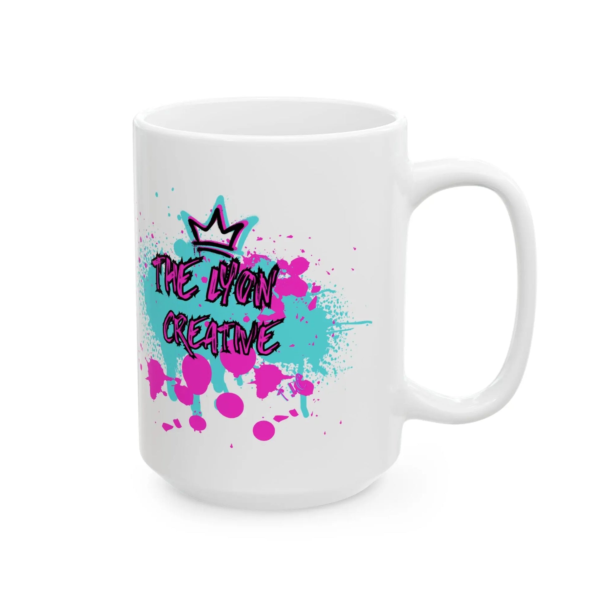 The Lyon Mug is a white ceramic coffee mug available in 11oz and 15oz sizes, featuring a colorful splatter design in teal and pink. It sports a crown along with the bold, stylized handwriting of "The Lyon Creative" on the side, providing a durable option for everyday use.