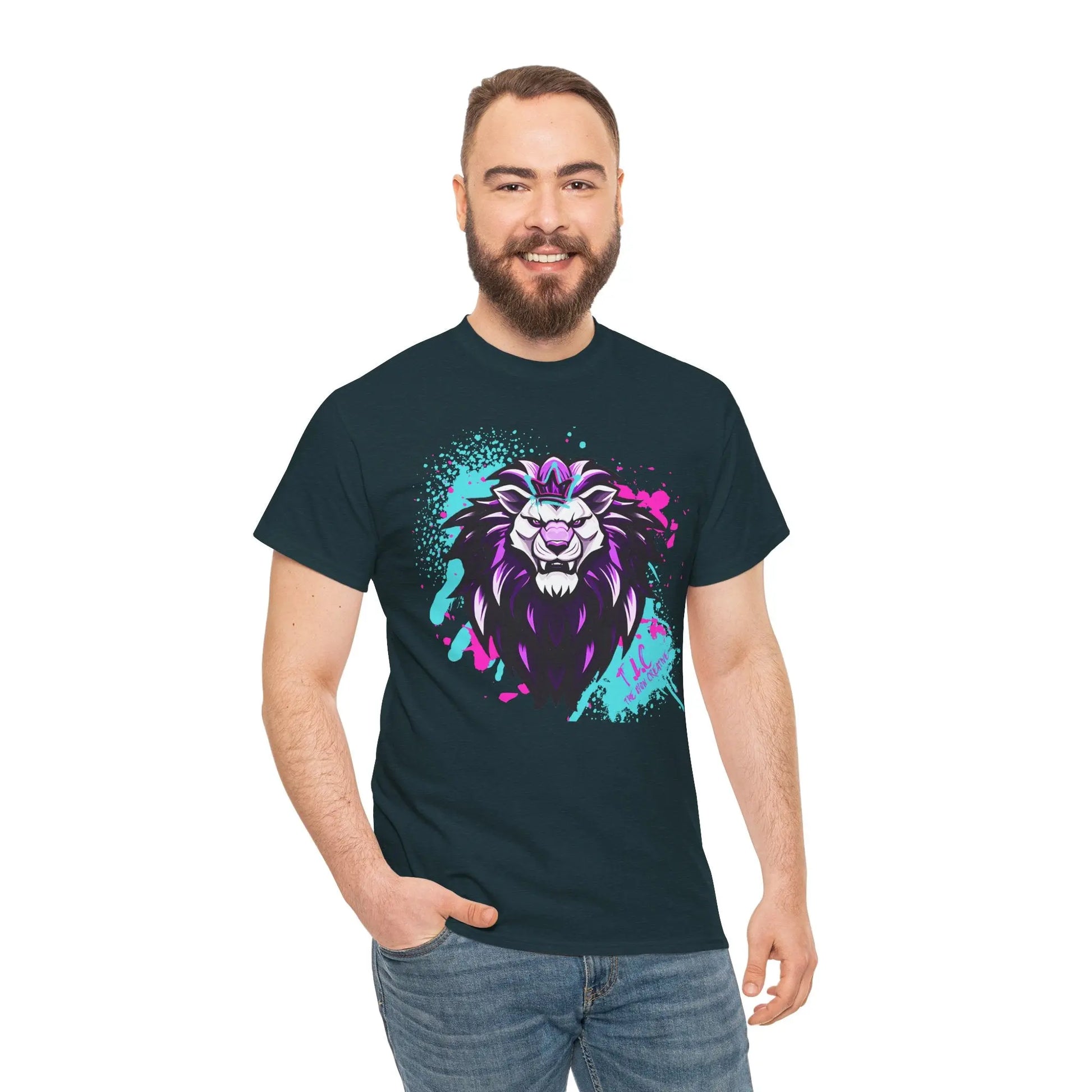 A man smiling in The Lyon T-shirt, a classic fit black tee made from 100% sustainable cotton, adorned with a colorful lion graphic featuring purple and teal accents, standing against a plain white background.