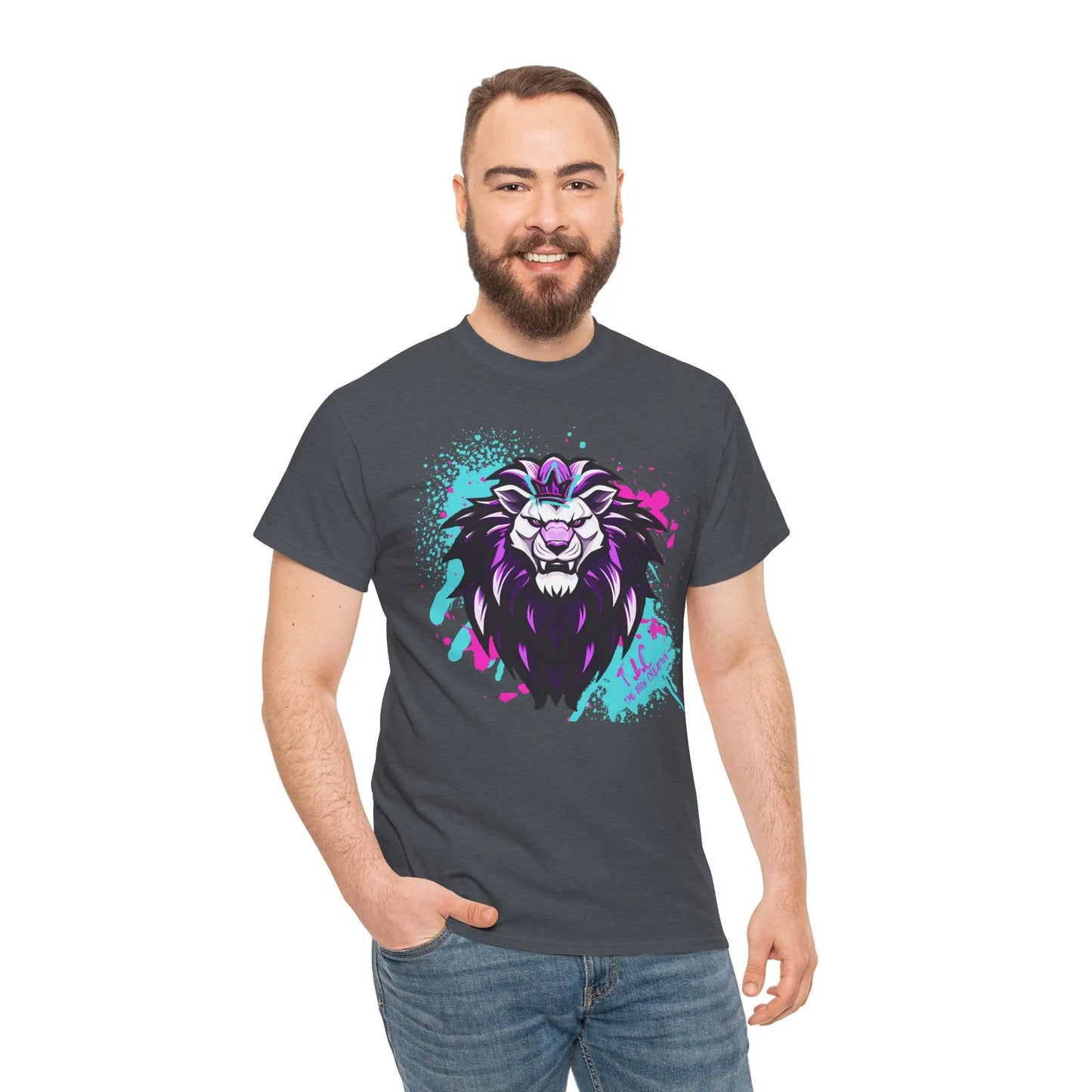 A bearded man is wearing The Lyon T-shirt, a classic fit, dark shirt adorned with a vibrant lion design. Crafted from 100% cotton, this shirt offers both sustainability and comfort. Standing against a plain white background, he smiles with one hand in his pocket.