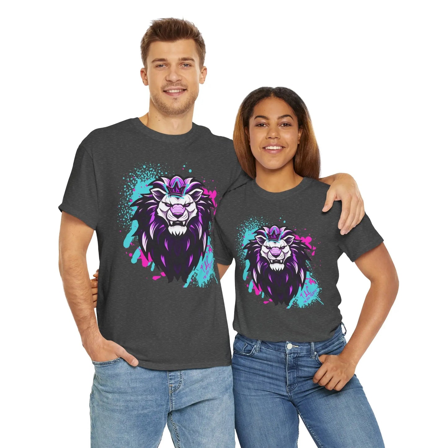 A smiling man and woman stand together, both wearing The Lyon T-shirt, which is crafted from 100% cotton and features a vibrant lion graphic in purple, blue, and pink colors. The woman has her arm around the man's shoulders. They are casually dressed in classic fit blue jeans.