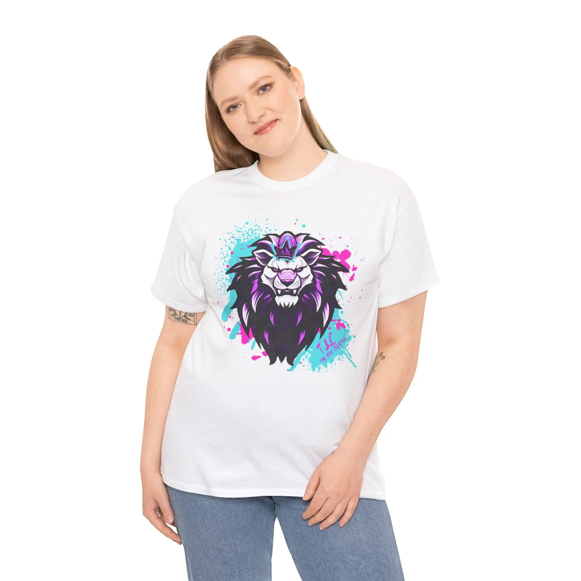 A person wearing "The Lyon T-shirt" featuring a vibrant lion design stands against a white background. The lion artwork blends purple and black tones with splashes of blue and pink on this classic fit shirt made from 100% cotton, perfectly matching their long, light brown hair.