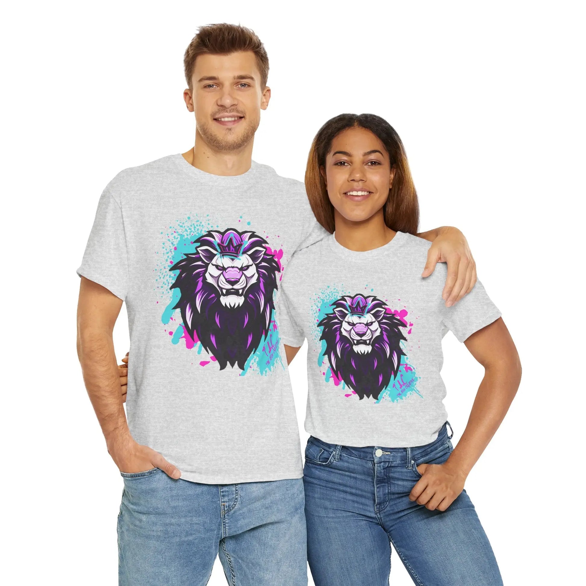 A smiling man and woman stand together, each wearing "The Lyon T-shirt," a classic fit gray shirt featuring a vibrant lion face graphic. Made from 100% cotton, the design explodes with splashes of purple, blue, and pink. They look happy and relaxed in their sustainable attire.