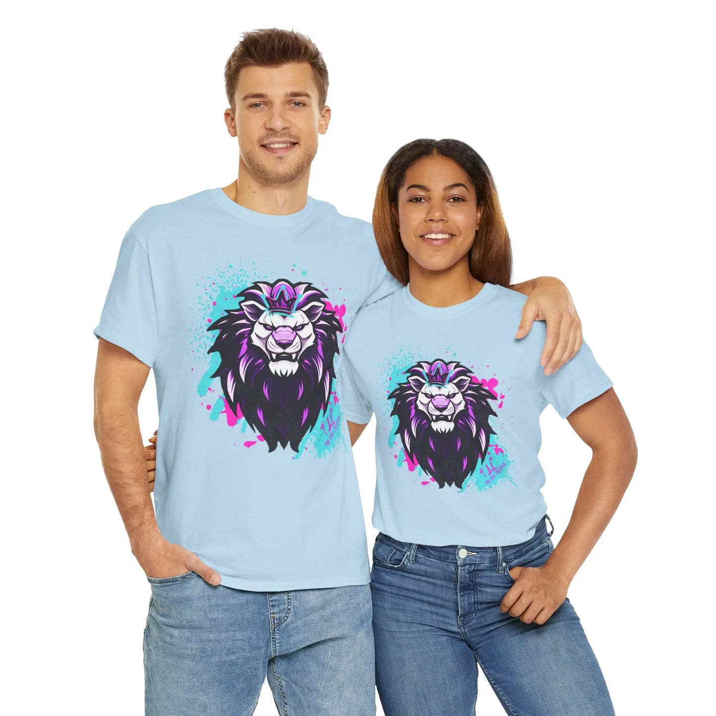 A man and woman are smiling in matching light blue "The Lyon T-shirt" made from 100% cotton, showcasing a striking graphic of a purple and black lion head. These classic fit shirts pop against the white backdrop as they stand close, with the man's arm wrapped around the woman's shoulder.