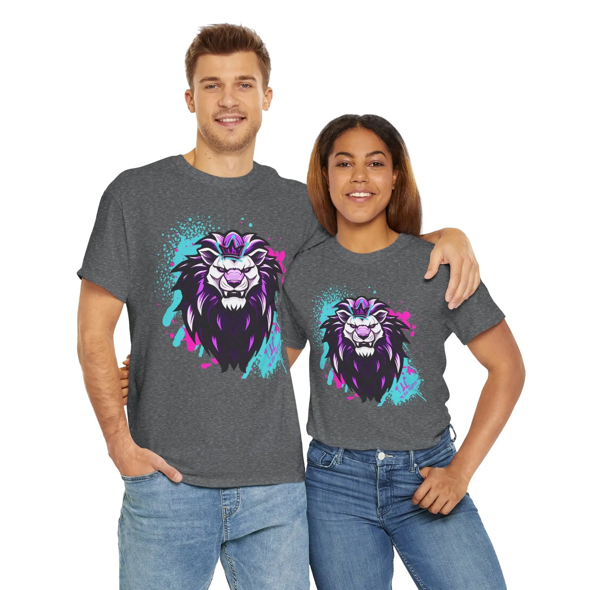 A man and woman smile at the camera, both sporting The Lyon T-shirt, a classic fit gray tee made from 100% cotton, adorned with a striking purple and blue lion graphic. The woman wraps her arm around the man's shoulder as they pose against a plain white background.