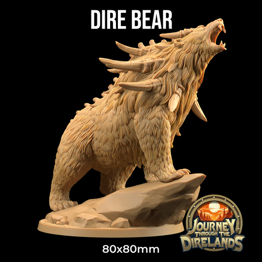 A detailed miniature figure of a roaring dire bear with prominent spikes on its back, standing on a rock base. The 3D printed sculpture is labeled "Dire Bear - The Dragon Trappers Lodge - 3d Print" at the top and has a "Journey Through the Direlands" logo at the bottom, perfect for Dungeons and Dragons campaigns. Size: 80x80mm.